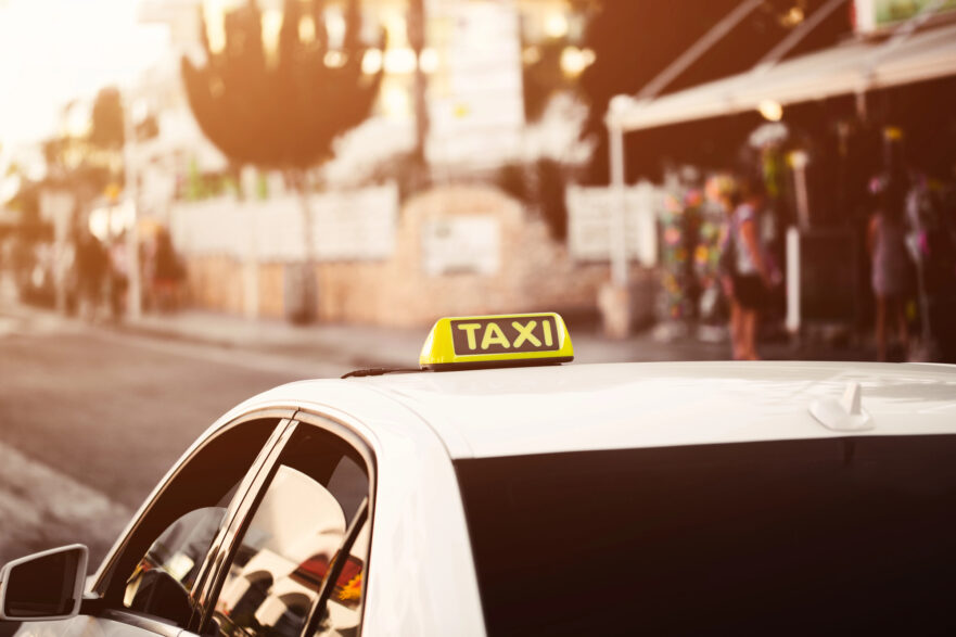 Yellow taxi sign. Taxi car on the street in city. Orange yellow warm toning bokeh background - Depositphotos_184110400_L